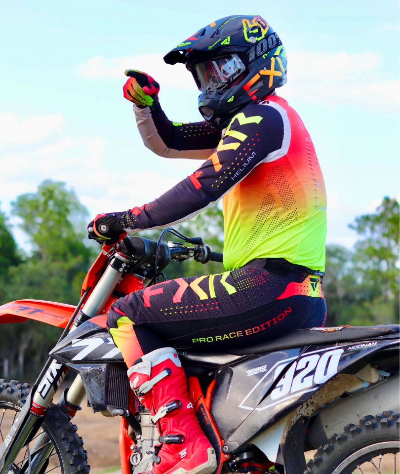 A person on a motorcycle with a helmet and gloves.